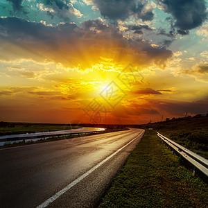 沥青路的日落戏剧性蓝色地平线阳光风暴运输交通运动街道太阳图片