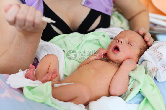 母亲用注射器喂养新生儿婴儿奶帮助哺乳期公式夹钳牛奶保健说谎腹部孩子男性图片
