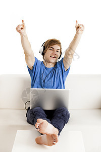 在沙发上快乐的男人长椅房子青少年蓝色成功爱好笔记本工作电脑享受图片
