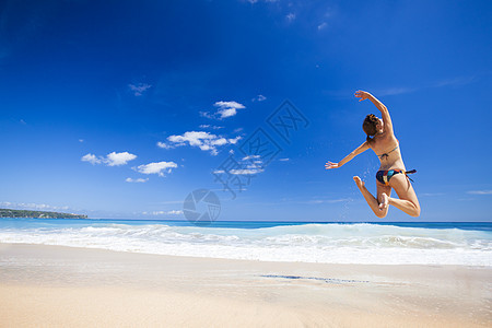 女人在海滩上跳跃幸福天堂假期热带游泳衣成人女性跑步女孩海洋图片