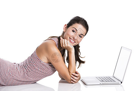 在笔记本电脑上工作的学生女孩说谎互联网青少年快乐白色技术女性黑发娱乐图片