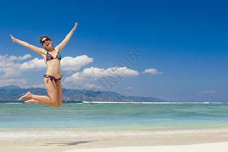 跳跃女孩女性太阳乐趣天堂身体闲暇海滩假期跑步图片