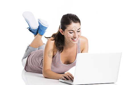 在笔记本电脑上工作的学生快乐女性技术地面白色娱乐说谎青少年微笑黑发图片