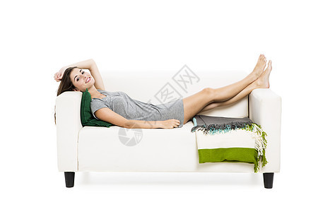 美丽的女人在沙发上放松黑发长椅幸福白色女孩房子休息微笑闲暇喜悦图片