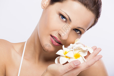 盛着鲜花的美女化妆品皮肤黑发温泉香味女孩女性鸡蛋花花朵微笑图片