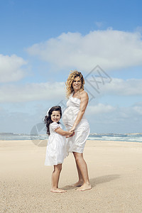 孕妇和她女儿在沙滩上的海滩上女性孩子家庭乐趣假期母性母亲幸福父母女孩图片