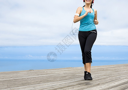 慢跑活动成人慢跑者行动女性音乐赛跑者天空训练微笑图片