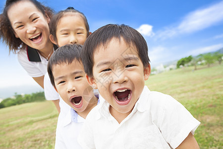 亚洲微笑的家庭 在草地上玩耍 阳光明媚的日子图片
