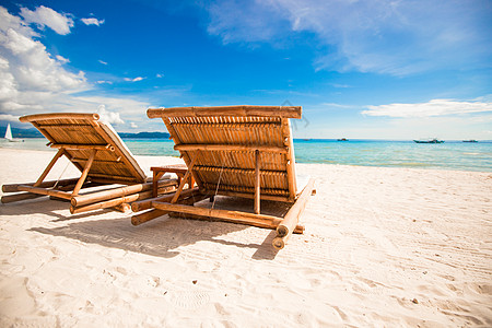 拥有雨伞和沙椅的热带空沙滩平地天堂景色情调海岸异国蓝色休息室海岸线旅行晴天椅子海景图片