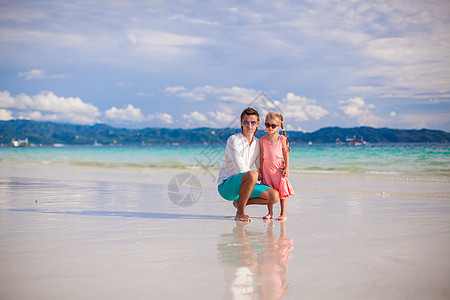 可爱的小女孩和年轻爸爸 在白沙滩上情调成人家庭海岸乐趣父亲女儿孩子海滩异国图片