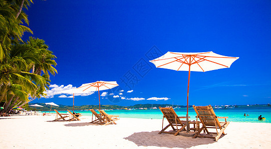 拥有雨伞和沙椅的热带空沙滩平地天堂景色放松蓝色海岸线海景海岸异国天蓝色晴天旅行情调图片