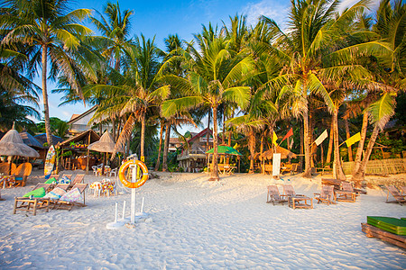 在一个奇异岛屿上日落的热带热带海滩日出游客地平线反射旅游运输海浪海景天空橙子图片