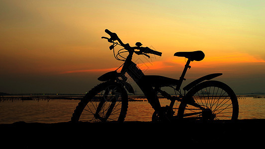 山上骑自行车的月光与日落天空假期娱乐速度日落车轮成人太阳旅行冒险运动图片