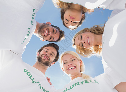 快乐的志愿者们聚集在蓝天上服务机构幸福志愿者道德活动家青年社区男人天空图片