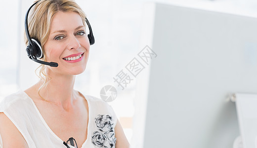 使用计算机佩戴头盔的随意妇女肖像工作中心办公室耳机客户职业女性服务商业女士图片