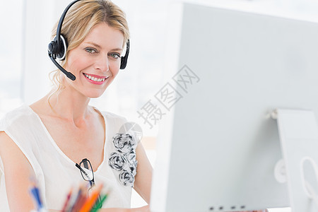 使用计算机佩戴头盔的随意妇女肖像职场代理人客户耳机工作操作员电脑显示器商业女士女性图片