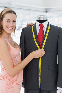 女时装设计员测量假体服装设计师卷尺微笑剪裁办公室女性套装模特工作礼服图片