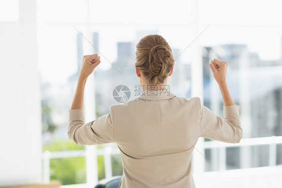 一位女商务人士在任时握紧拳头的身后图片