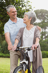 在公园骑自行车的老年夫妇亲热成人女士农村女性夫妻闲暇灰色锻炼男人图片