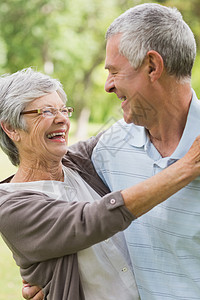 快乐的高级女子在公园拥抱男人女性感情人员男性退休成人老年闲暇笑声头发图片