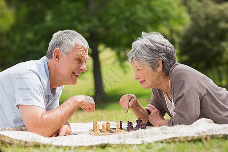快乐的老夫妇在公园下棋棋盘地毯老年女士人员女性短发头发幸福游戏图片