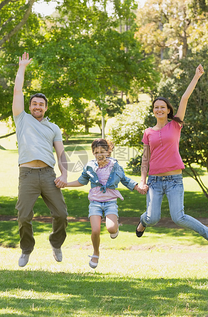 三个人一家三口手握手 在公园跳跃快乐男人活力男性童年家庭闲暇父母女孩女儿图片