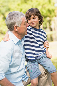 祖父和儿子在公园里微笑男人成人树木男生老年亲热男性孩子祖父母孙子图片