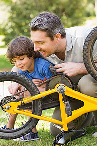 父亲和儿子修自行车帮助身份男生男性男人车轮家庭教学学习孩子图片