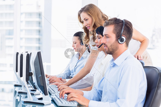 使用计算机佩戴头盔的经理和主管职场耳机女士代理人中心女性商业操作员商务同事图片