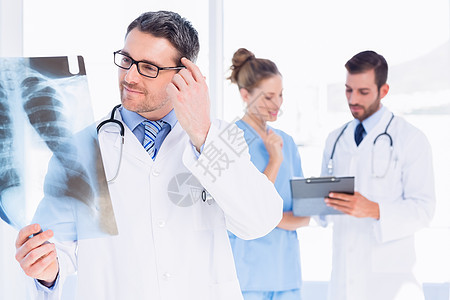 男医生与后面的同事一起检查X光放射科专家男性女士职业x射线团队医院办公室女性图片