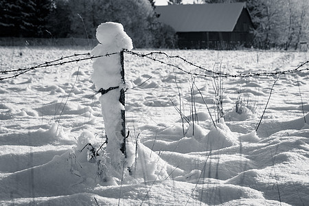 带雪雪的刺铁丝栅栏蓝色场地牧场天空倒钩漂移薄雾脚印天气照片图片