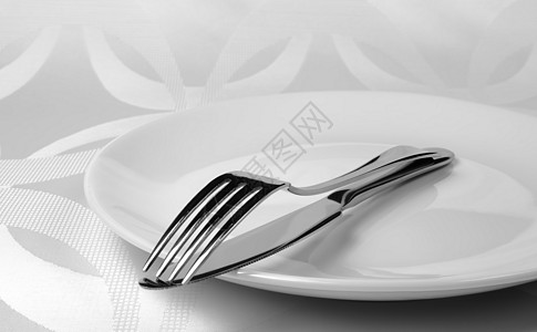 刀和叉在盘子上厨房刀具陶器不锈钢亚麻餐巾棉布餐具背景图片