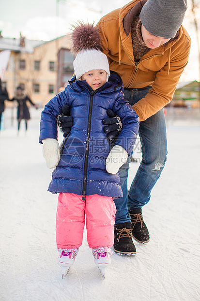 年幼父亲教他女儿滑溜冰在水晶上手套运动闲暇婴儿女孩教育锻炼童年冰鞋孩子图片