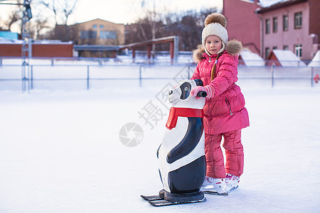 快乐的小女孩学习滑冰 在水晶上女孩喜悦冰鞋数字企鹅运动溜冰场生活方式手套孩子图片
