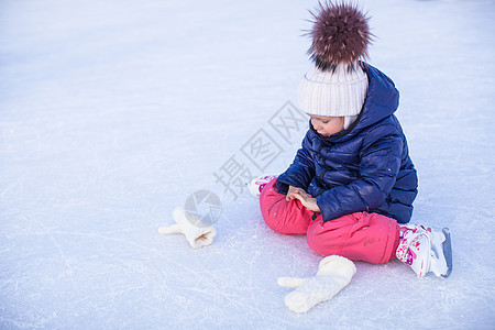 秋天后 可爱的小女孩坐在冰上 穿着溜冰鞋坐着冰雪教学溜冰者滑冰小姑娘闲暇女儿婴儿训练女性爱好图片