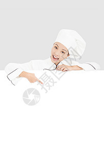微笑的年轻女厨师用空白板指着职业衣服女孩职员工作烹饪成人食物商业木板图片