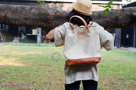 年轻女人拿着帆布袋女性街道女孩帆布木头衣服皮革魅力成人榕树图片