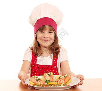 快乐的小女孩用鲑鱼海鲜做饭食物午餐帽子微笑烹饪美食厨师柠檬蔬菜女孩图片