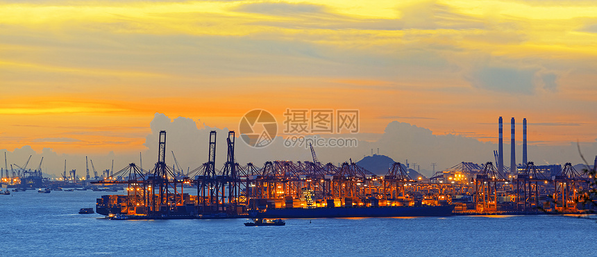 在日落时拍摄的港口几架起重机的轮廓造船制造业橙子框架船厂码头工程天空工作加载图片