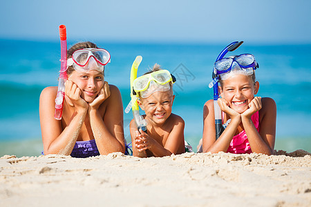 海滩上三个快乐的孩子呼吸管女孩乐趣潜水女性海洋旅行运动蓝色活动图片