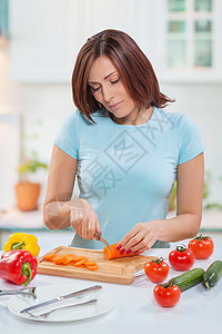 女性用餐桌上的厨房刀切胡萝卜图片