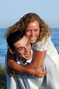 年轻情侣玩得开心金发喜悦牙齿恋人海滩面孔幸福女性微笑友谊图片