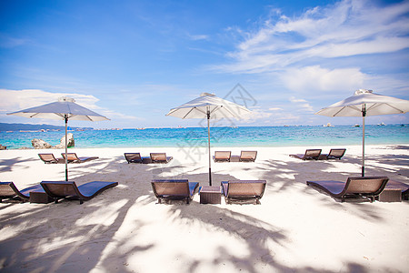 拥有雨伞和沙椅的热带空沙滩平地天堂景色旅行海景海岸天蓝色椅子蓝色海岸线晴天休息室图片