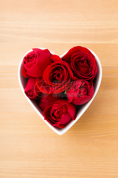 红玫瑰在木本底的心形碗里念日婚姻礼物木头花束粉色玫瑰红色花瓣踏板图片