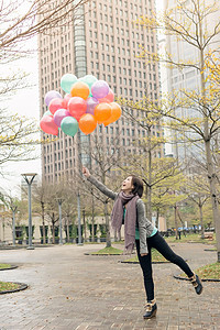 快乐笑笑的亚洲女人拿着气球快乐女士女性公园魅力乐趣微笑图片