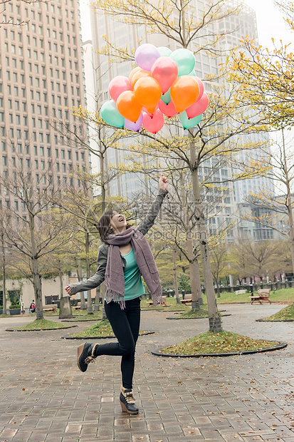 快乐笑笑的亚洲女人拿着气球快乐魅力女士女性公园乐趣微笑图片