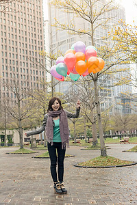 快乐笑笑的亚洲女人拿着气球女士快乐女性微笑乐趣魅力公园图片