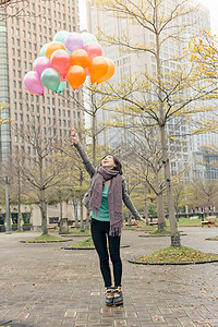 快乐笑笑的亚洲女人拿着气球魅力乐趣女士女性快乐公园微笑图片