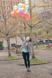 青年妇女玩耍和持有气球微笑女士魅力乐趣快乐公园女性图片