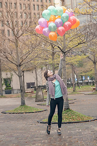 青年妇女玩耍和持有气球公园微笑快乐女士女性魅力乐趣图片